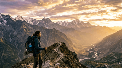 Backpacker on a mountain ridge overlooking a valley at golden hour